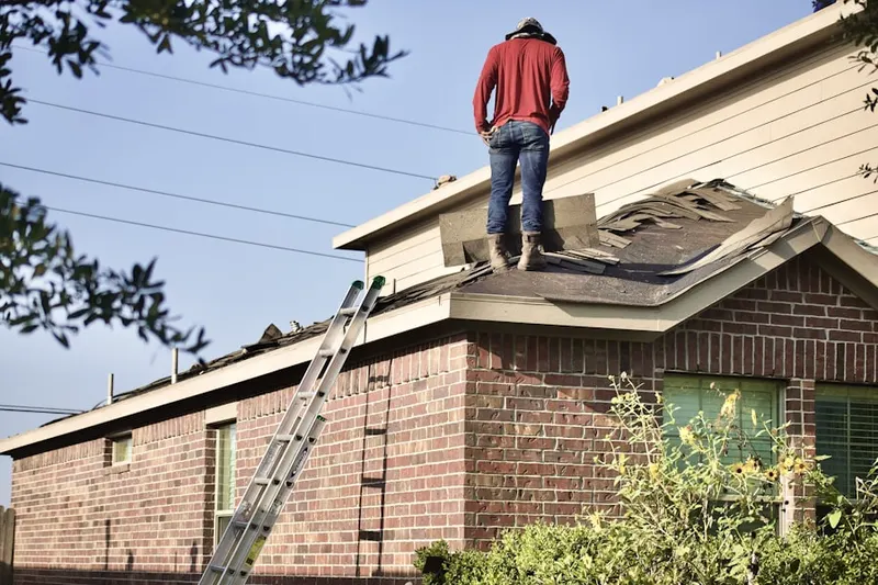 Professional roofer working on a residential roof in Penn Hall